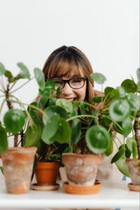 Woman smiling behind plants