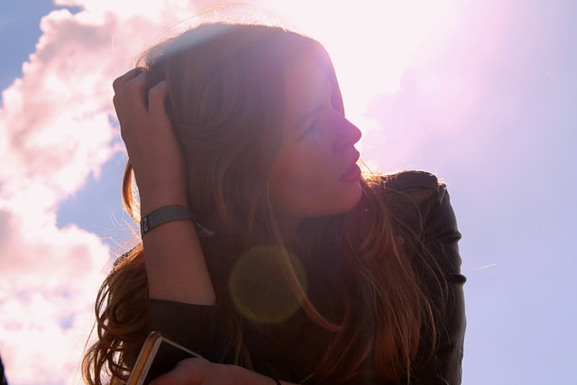 silhouette of a woman with long hair with glow from the sun behind her